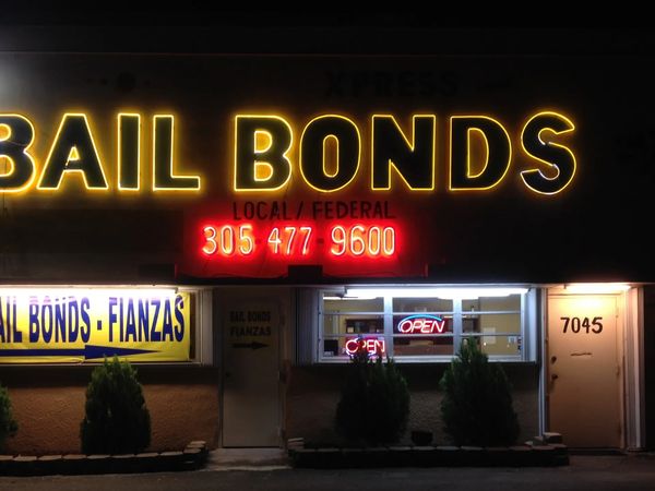 Xpress Bail Bonds storefront at night, neon BAIL BONDS sign glowing